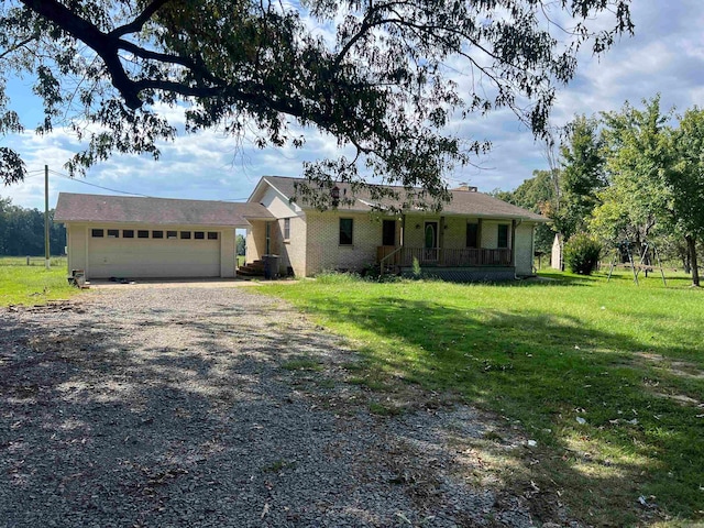 ranch-style home with a front lawn, a porch, and a garage