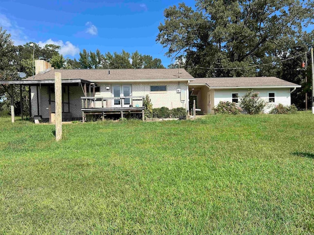 back of property featuring a yard and a wooden deck