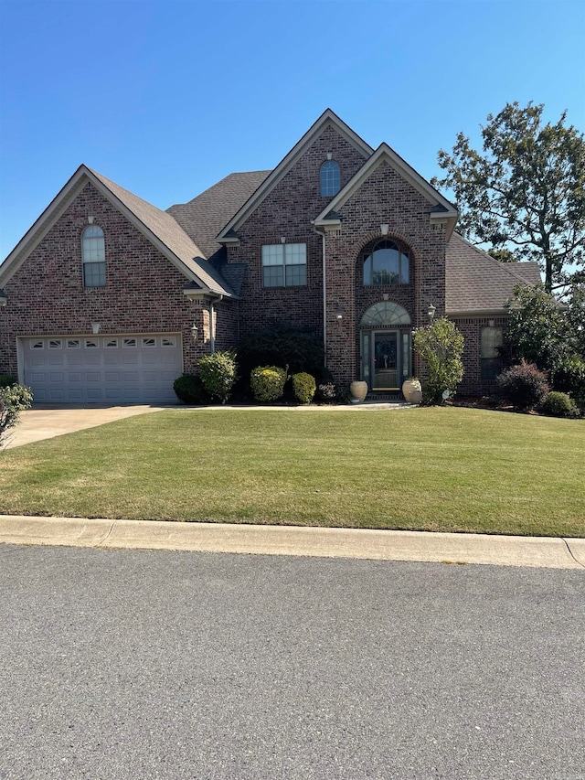 view of front of property with a garage and a front lawn