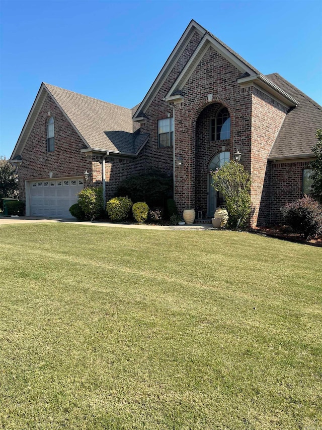 front facade with a garage and a front lawn