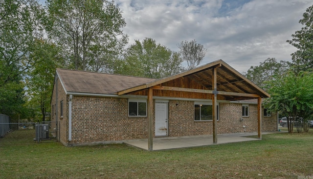 rear view of house with a yard, a patio area, and central AC unit