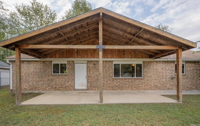 back of property featuring a patio and a lawn