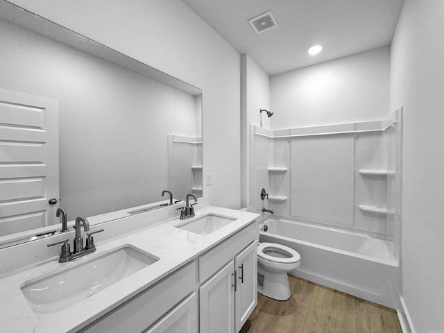 full bathroom with vanity, hardwood / wood-style floors, shower / tub combination, and toilet