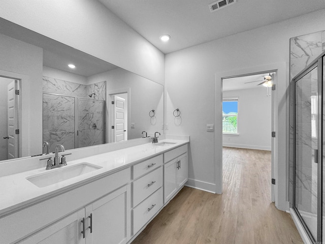 bathroom featuring ceiling fan, wood-type flooring, a shower with door, and vanity