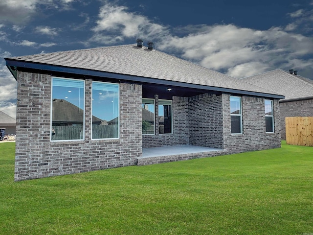 rear view of property featuring a patio and a lawn