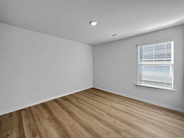 spare room with light hardwood / wood-style flooring