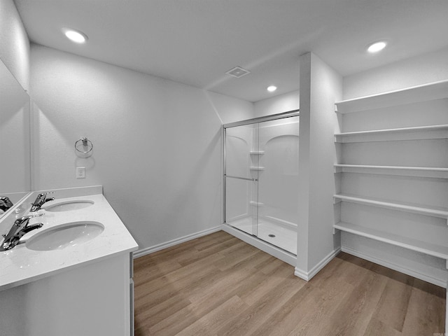 bathroom with a shower with door, wood-type flooring, and vanity