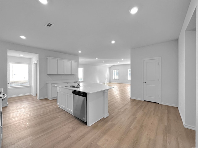 kitchen featuring white cabinetry, light wood-type flooring, stainless steel dishwasher, and a kitchen island with sink