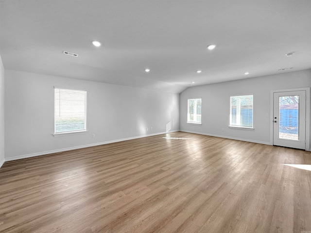 spare room with vaulted ceiling and light wood-type flooring