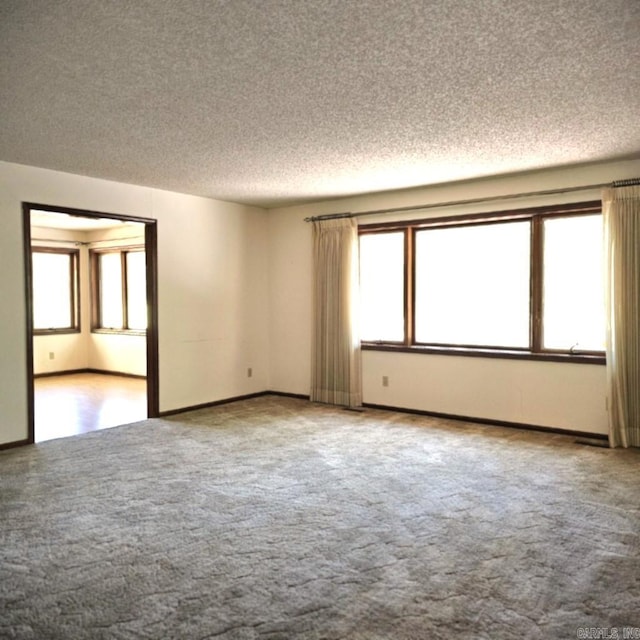 empty room with a textured ceiling and carpet flooring