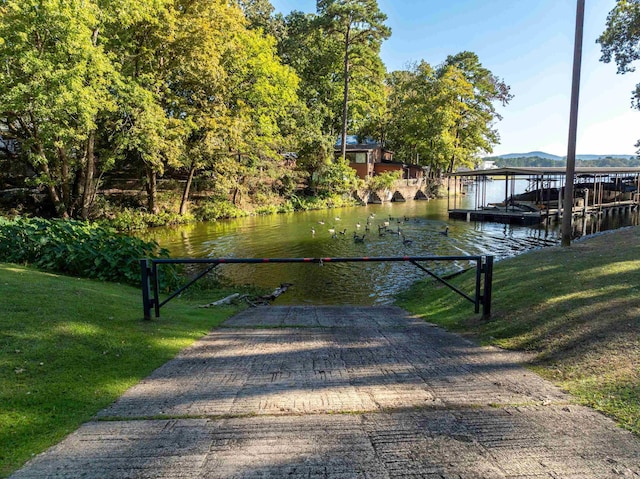 view of dock featuring a water view and a yard