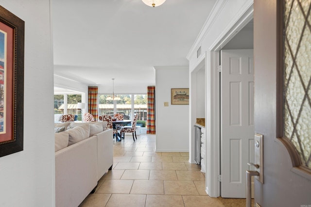 interior space with crown molding, an inviting chandelier, and light tile patterned floors