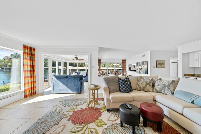 tiled living room with ceiling fan, ornamental molding, and a water view