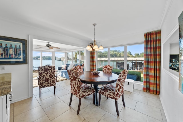 tiled dining room with ceiling fan with notable chandelier, a water view, crown molding, and plenty of natural light