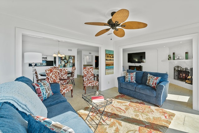 living room featuring light tile patterned flooring, ceiling fan with notable chandelier, a fireplace, and crown molding