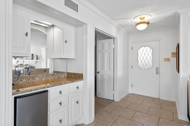 entrance foyer with ornamental molding and light tile patterned floors