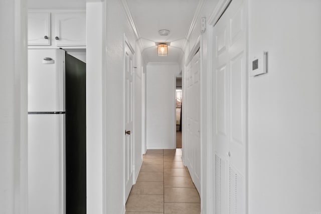 hall featuring crown molding and light tile patterned floors