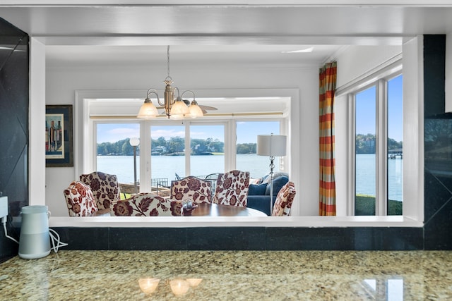 interior space featuring a water view, crown molding, and a chandelier