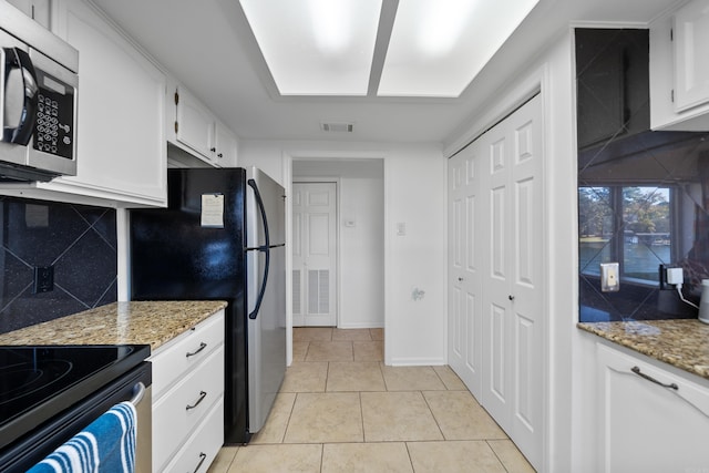 kitchen featuring decorative backsplash, appliances with stainless steel finishes, light stone counters, and white cabinetry