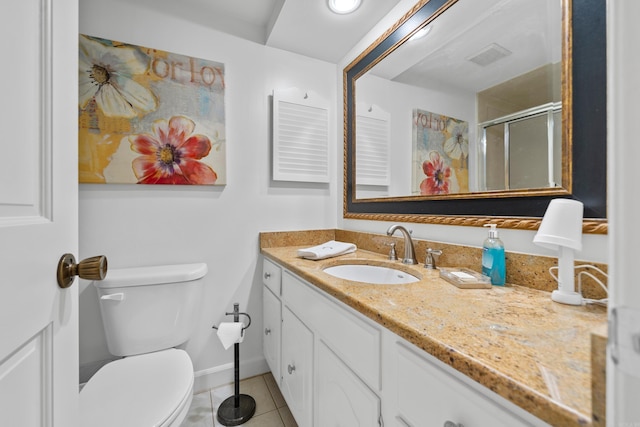 bathroom with tile patterned floors, vanity, walk in shower, and toilet