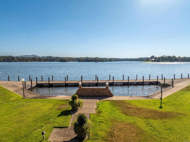 dock area with a water view and a yard