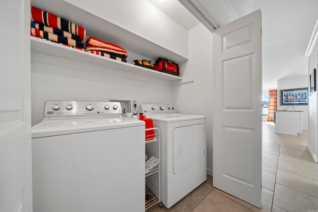 washroom with light tile patterned flooring and washer and dryer