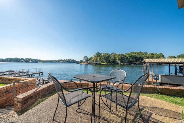 view of patio with a water view and a boat dock