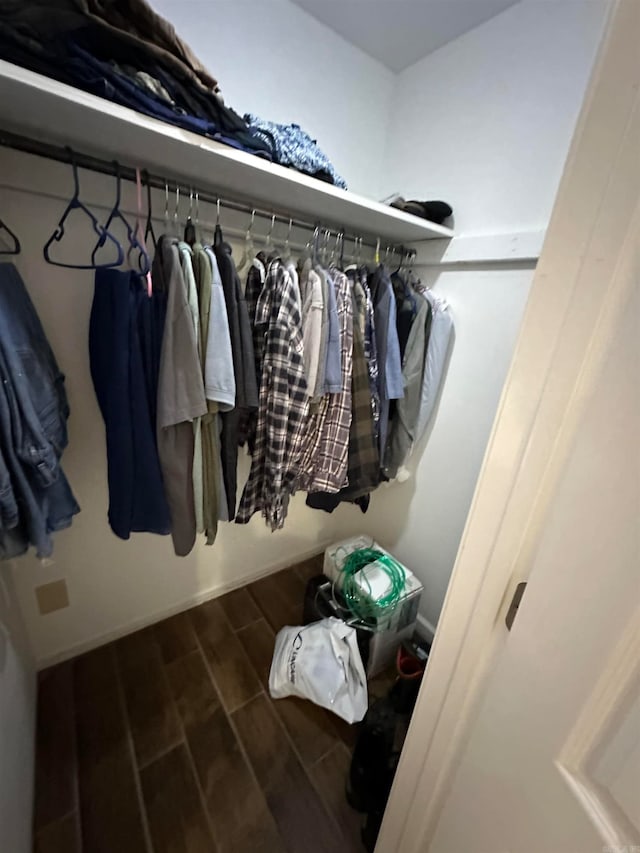 walk in closet with dark hardwood / wood-style floors