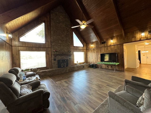 living room with ceiling fan, beamed ceiling, wood walls, wood-type flooring, and high vaulted ceiling