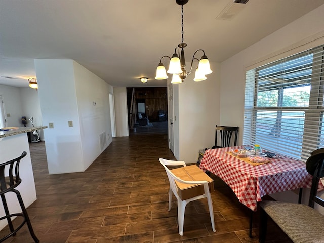 dining room featuring a notable chandelier and dark hardwood / wood-style flooring