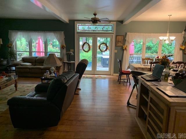 living room with beam ceiling, french doors, wood-type flooring, and ceiling fan with notable chandelier