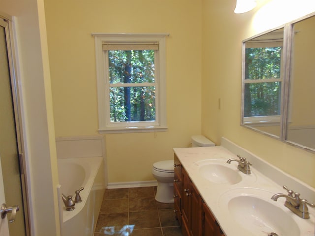 bathroom with tile patterned floors, a washtub, vanity, and toilet