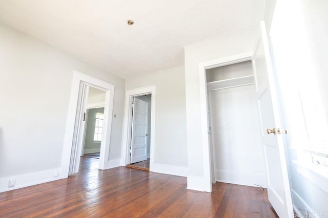 unfurnished bedroom featuring a closet and dark hardwood / wood-style flooring