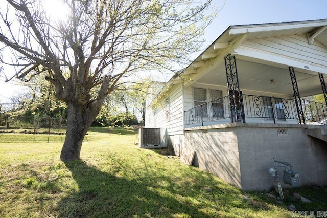 view of side of home featuring central air condition unit and a lawn