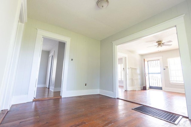 spare room featuring ceiling fan and dark wood-type flooring