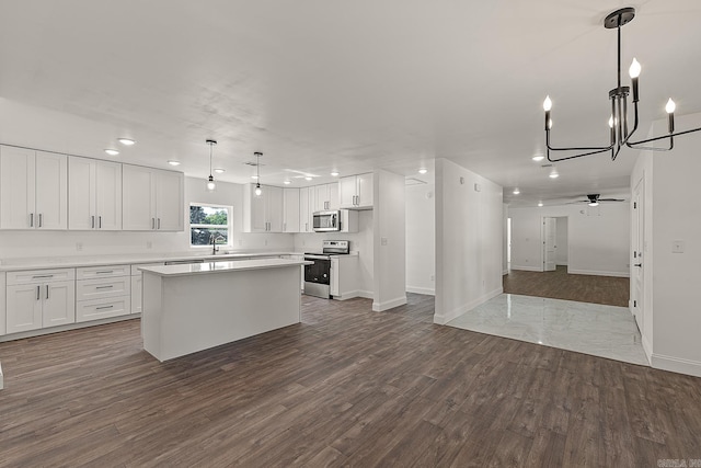 kitchen featuring stainless steel appliances, dark hardwood / wood-style flooring, and white cabinetry