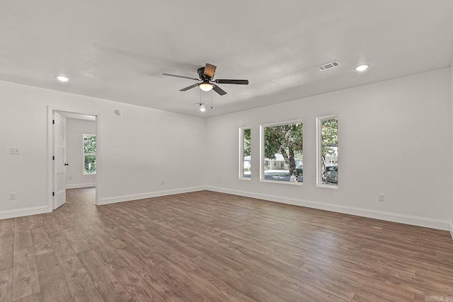 spare room featuring a healthy amount of sunlight, ceiling fan, and light hardwood / wood-style floors