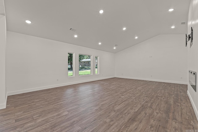 unfurnished room with hardwood / wood-style flooring, lofted ceiling, and a barn door