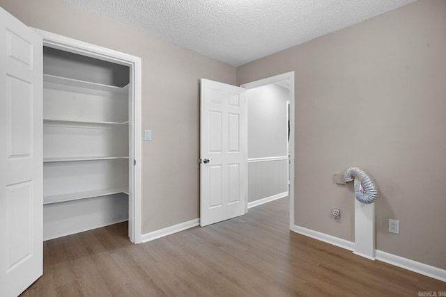 unfurnished bedroom featuring a closet, hardwood / wood-style floors, and a textured ceiling