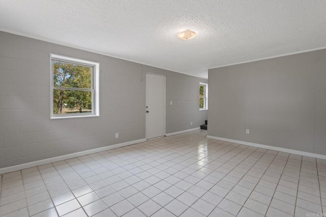 unfurnished room with crown molding, light tile patterned floors, and a textured ceiling