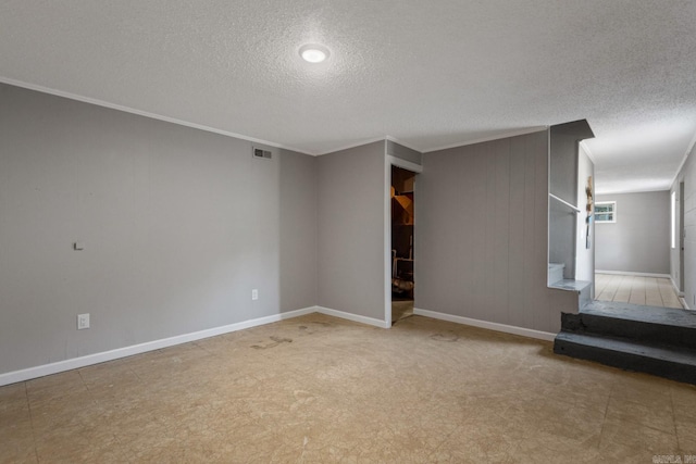 unfurnished living room with ornamental molding and a textured ceiling