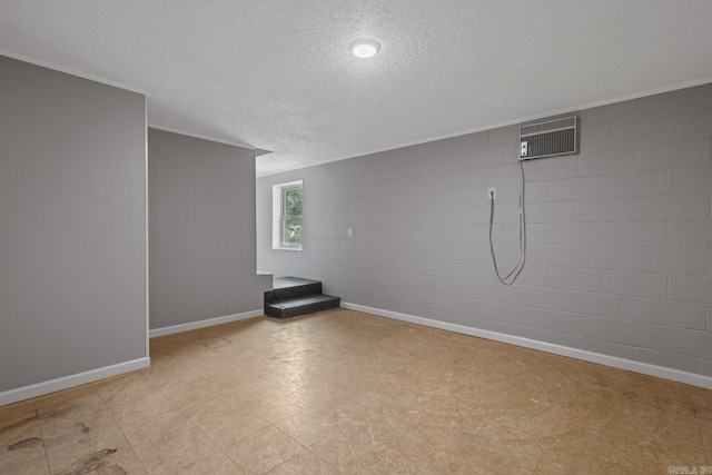 basement featuring a wall unit AC, crown molding, and a textured ceiling