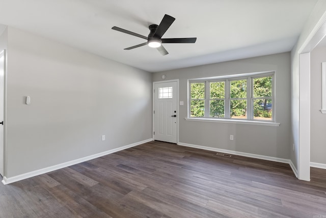 foyer entrance with ceiling fan and dark wood-type flooring