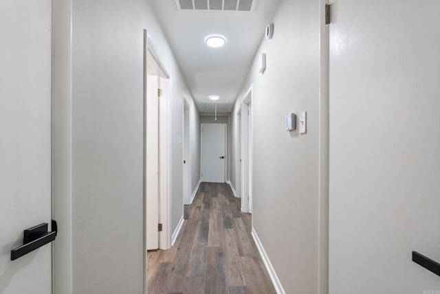 corridor with hardwood / wood-style flooring