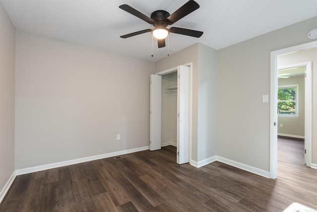 unfurnished bedroom featuring a closet, dark hardwood / wood-style flooring, and ceiling fan