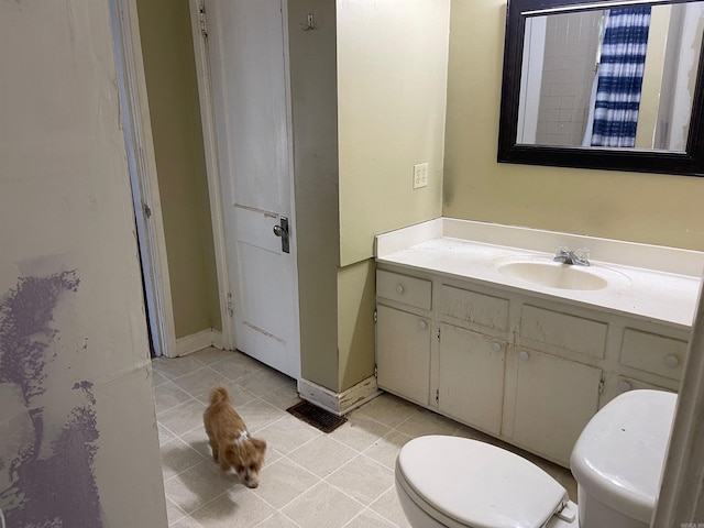 bathroom featuring tile patterned floors, vanity, and toilet