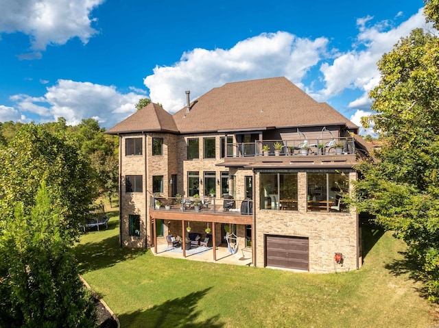 rear view of property featuring a trampoline, a yard, a patio, and a balcony