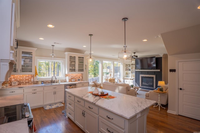 kitchen featuring dark hardwood / wood-style flooring, hanging light fixtures, a center island, and white cabinets