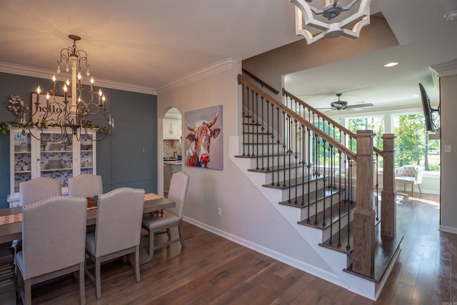 dining area featuring ornamental molding, dark wood-type flooring, and ceiling fan with notable chandelier