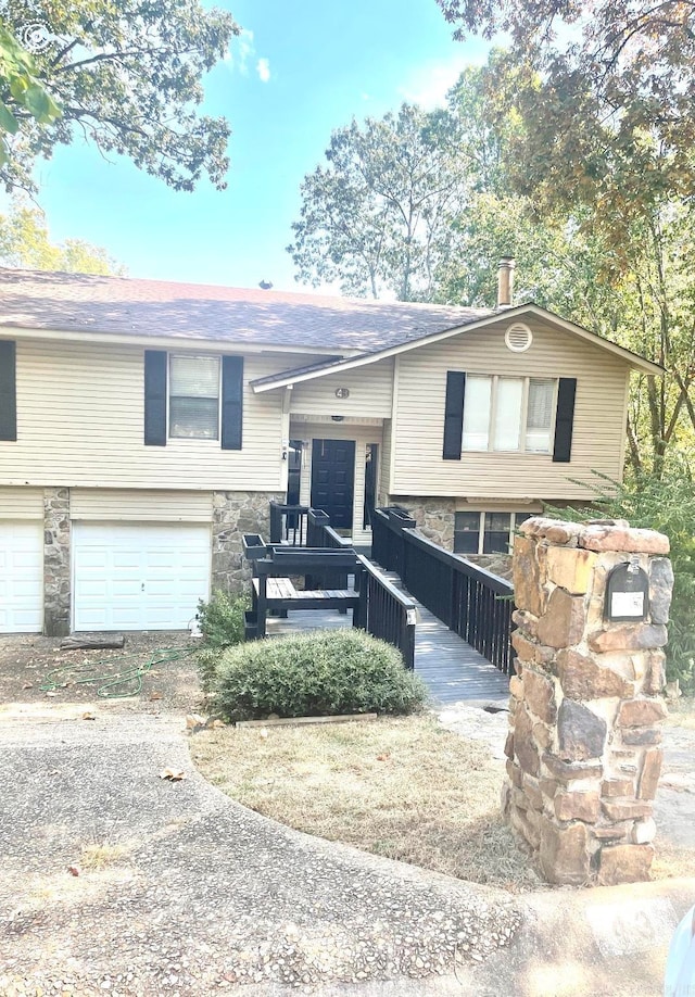 bi-level home featuring a wooden deck and a garage